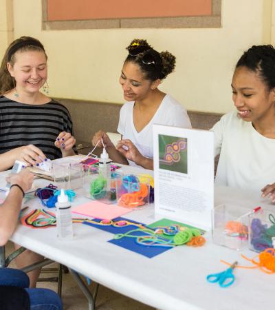 students working at table covered in craft supplies