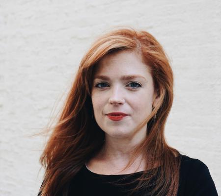 Hallie Ringle standing in front of a white background in a black shirt