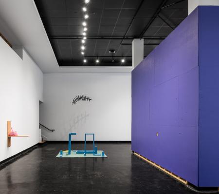 Installation with purple and white walls surrounding a freestanding object