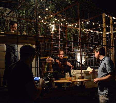 students performing at night and trying to sell block of wood