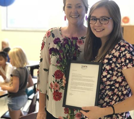 image of a student teacher and another teacher standing side by side an award