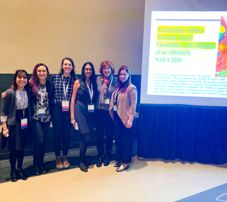 six women presenters standing in front of a presentation screen at a conference