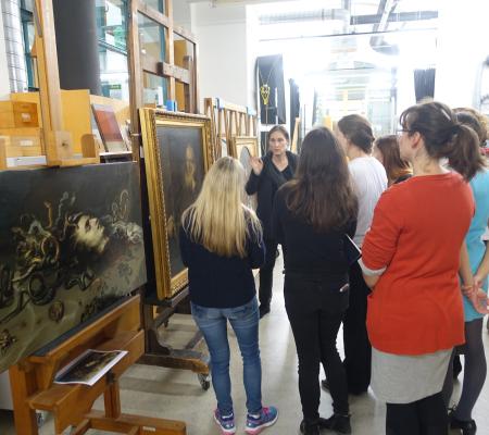 group gathered around work behind the scenes in a gallery