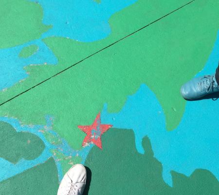 two shoes visible on colored concrete floor with red star