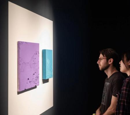 two people looking at art on wall in gallery